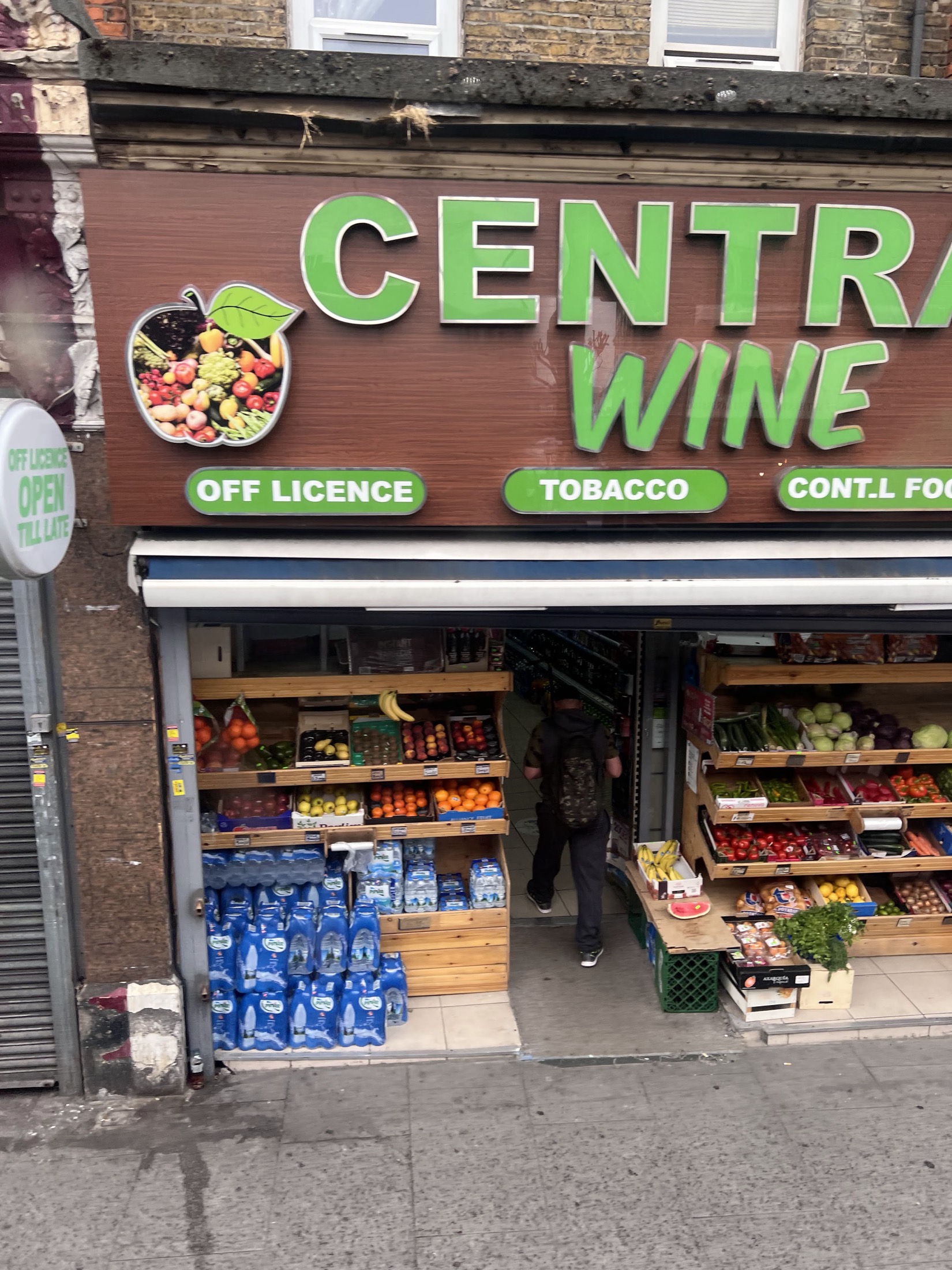 The open Central Wine shopfront with fresh fruit and veg stacked on both sides of the doorway and bottled water by the entrance.